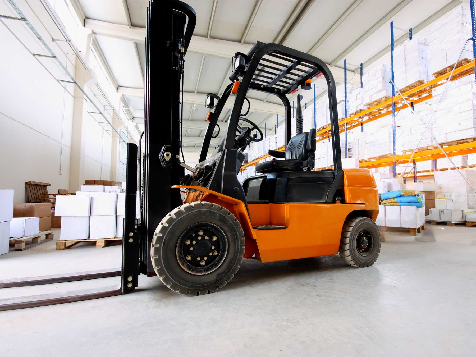 orange forklift in operation in a warehouse orange forklift in operation in a warehouse